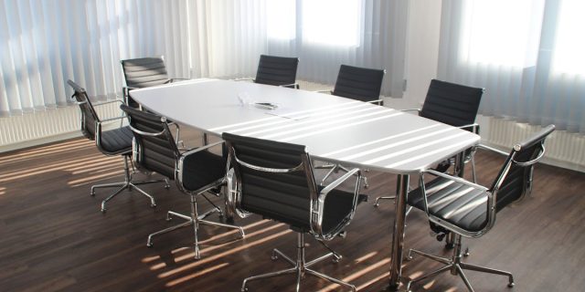 Modern office meeting room with designer chairs, table, and large windows.